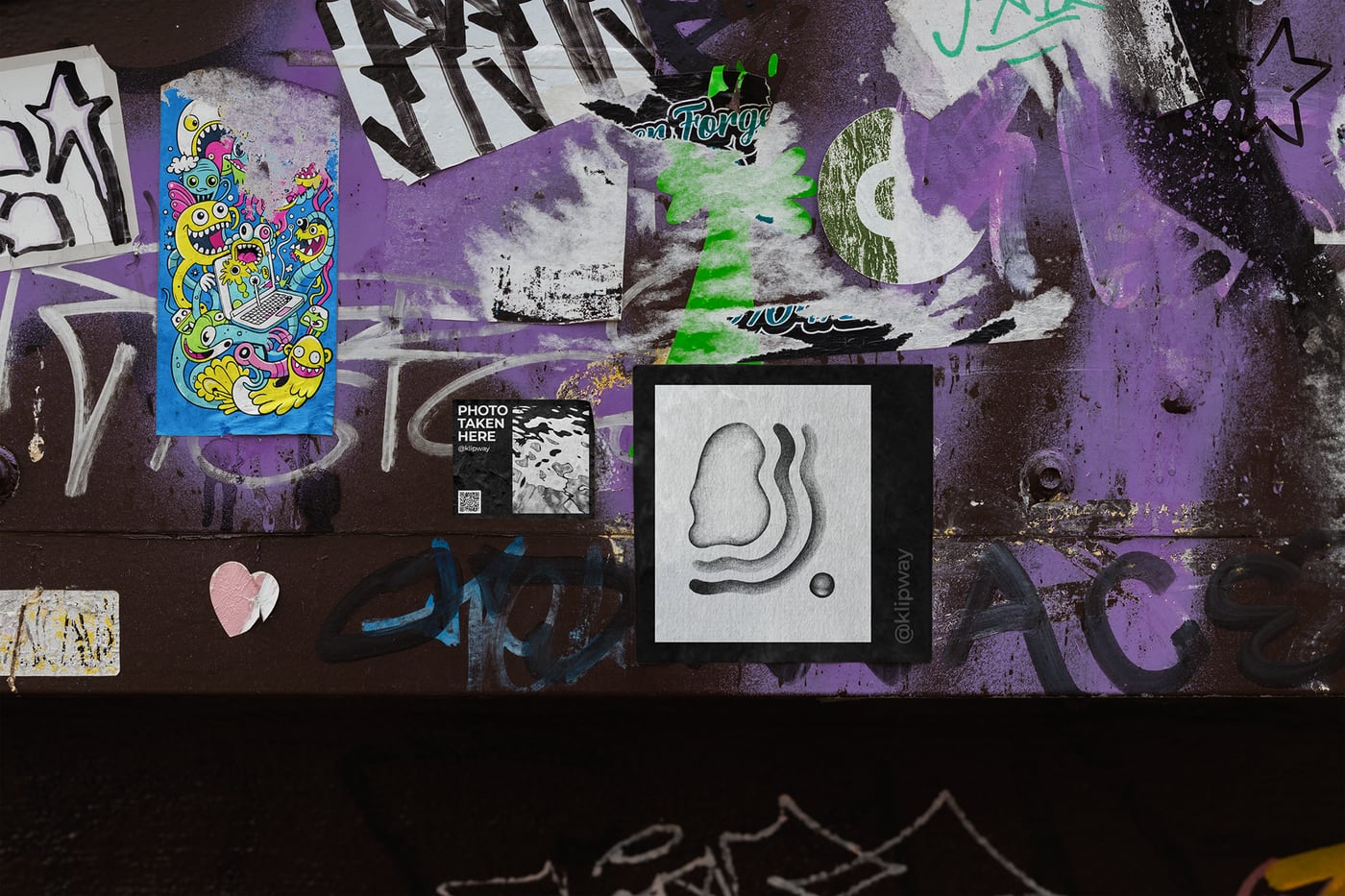 One of the stickers pasted on a graffiti-covered wall among other street art.
