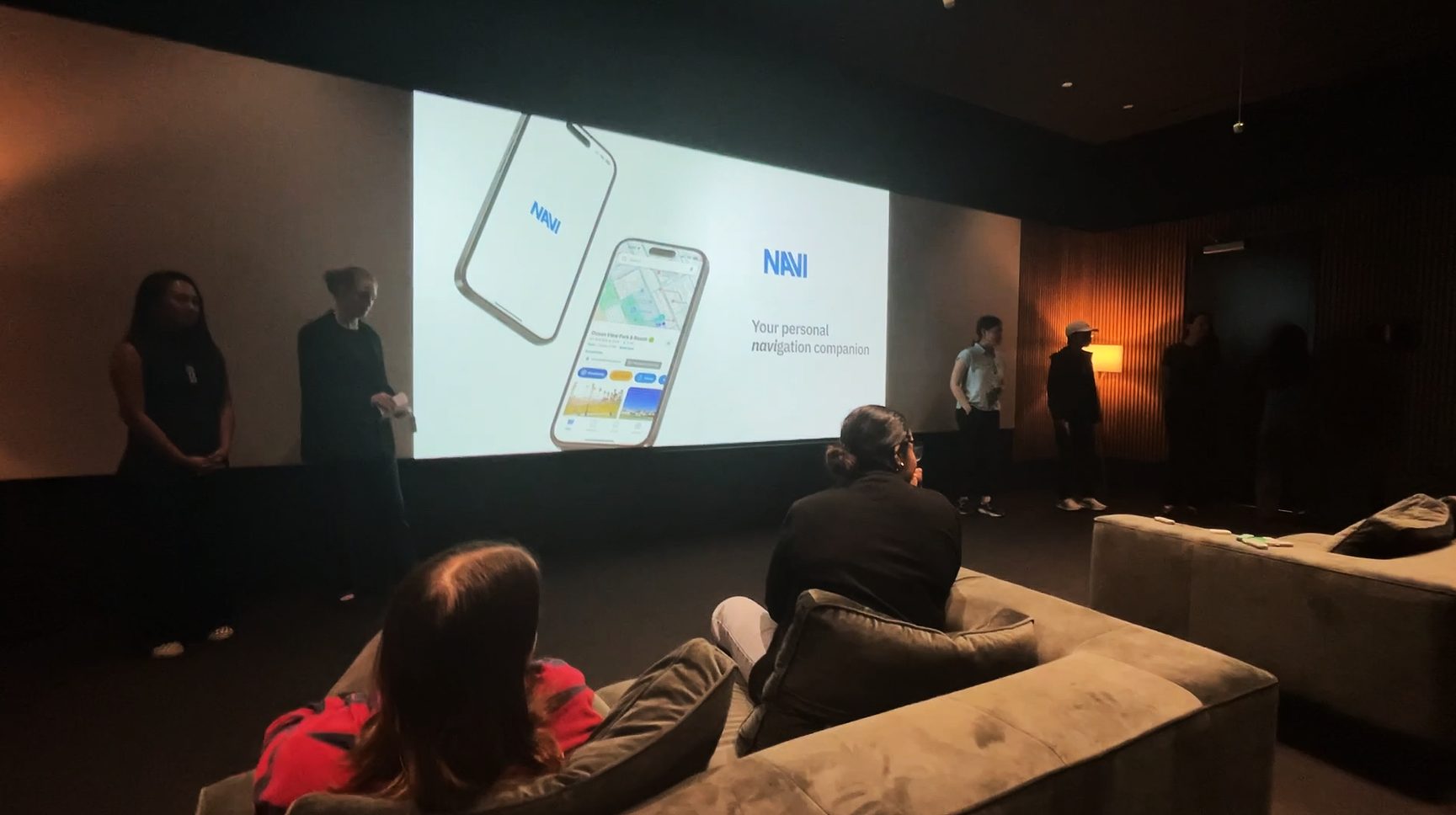 The team presenting NAVI at BMW Designworks, the title slide on a large screen reading "Your personal navigation companion", with the audience seated in front.