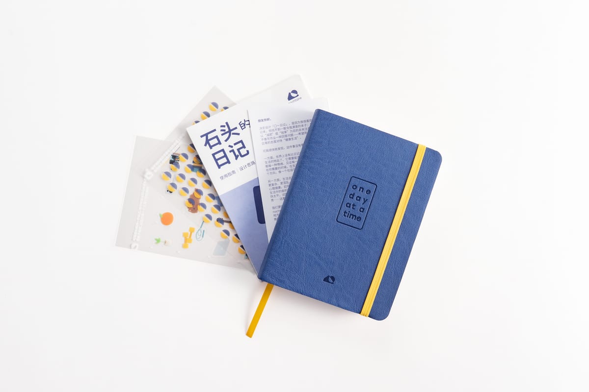 The journal from above, the pamphlet and sticker pouch fanned out behind it.