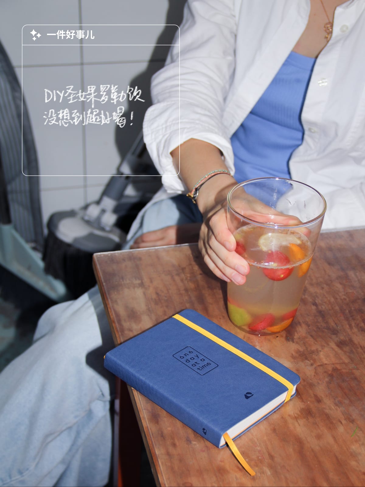 A social post: a homemade drink and the journal on a weathered wooden table, overlaid with the one good thing module.