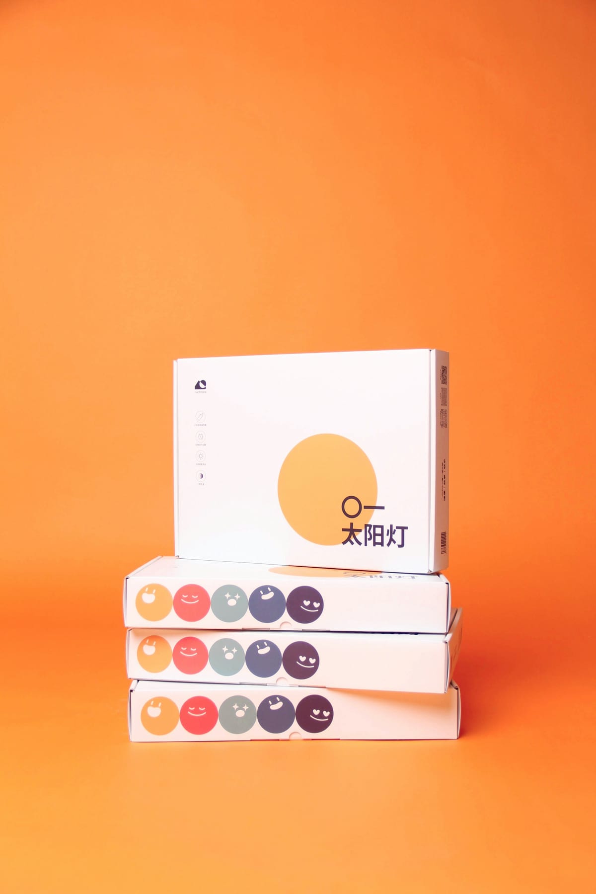 Four retail boxes stacked on an orange backdrop.