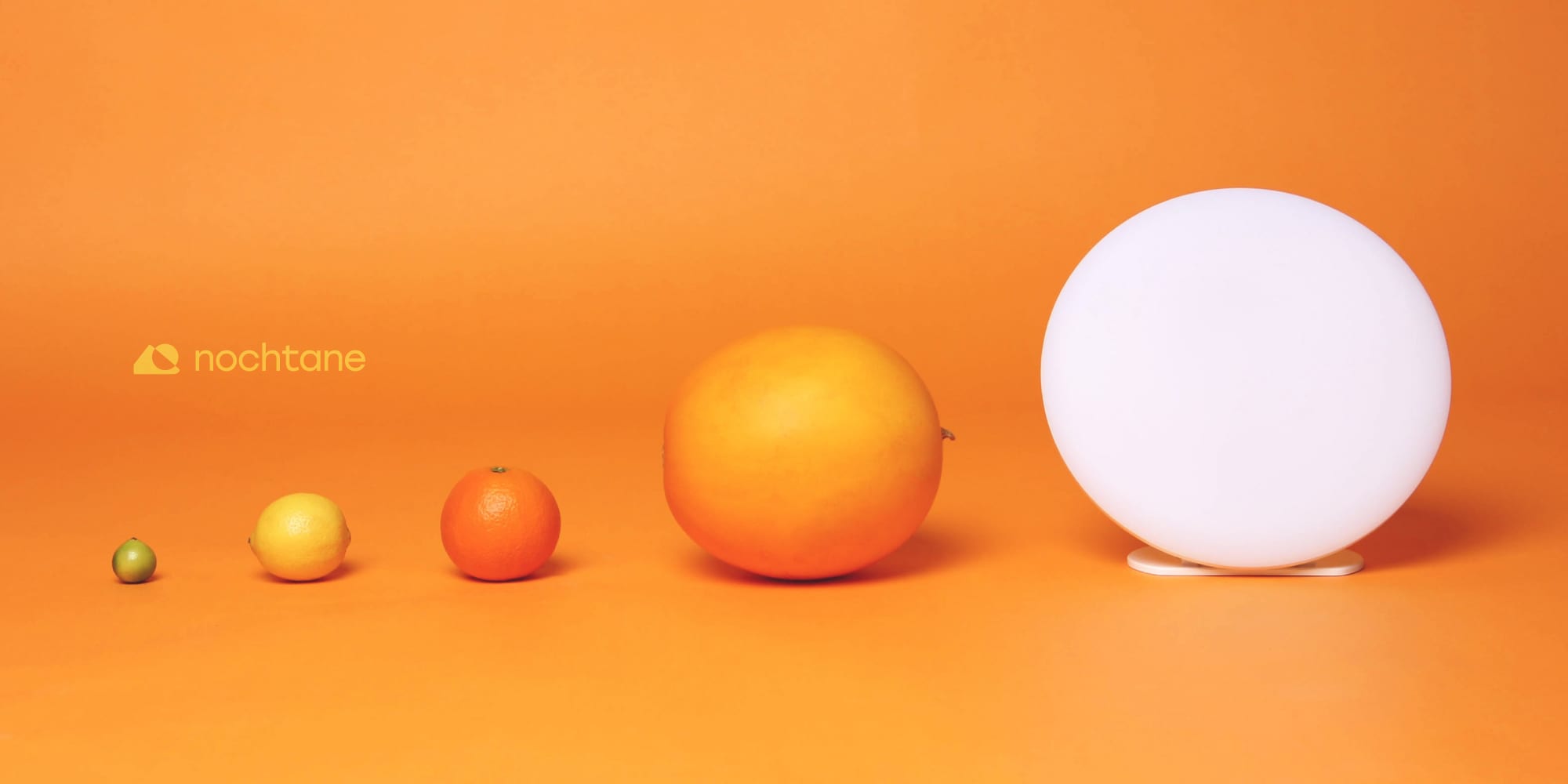 The O1 Sun Lamp lit on an orange backdrop beside a lime, a lemon, an orange, and a grapefruit, each a step larger, with the nochtane lockup at the left.