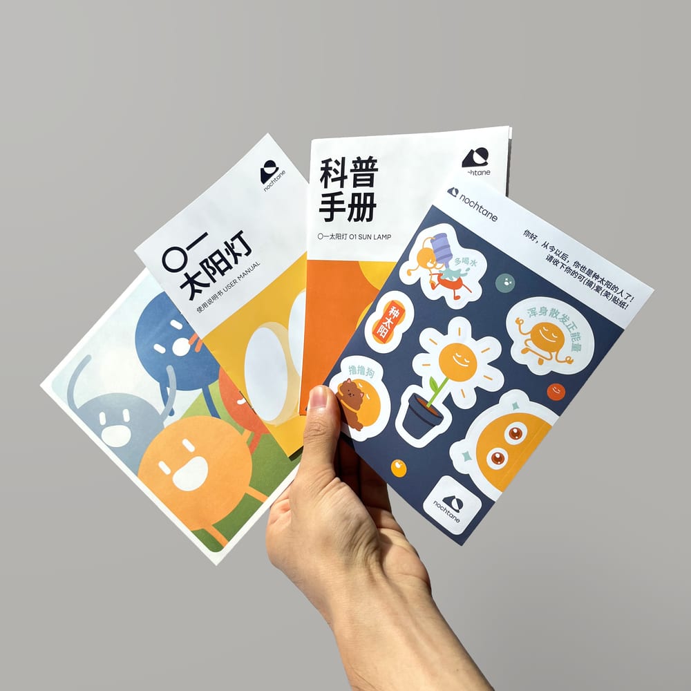 The user manual, science pamphlet, and sticker sheet, held in a fan.