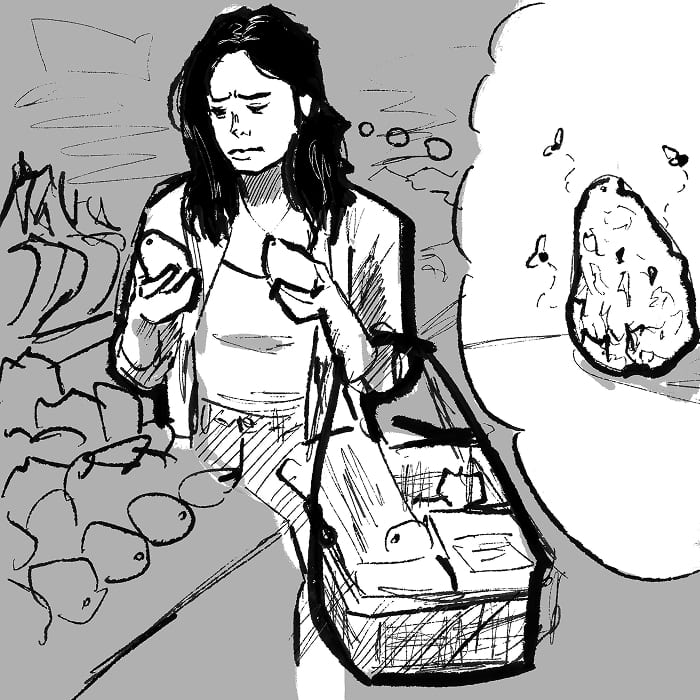 A shopper in the produce aisle picks up one avocado after another, squeezing each to judge it.