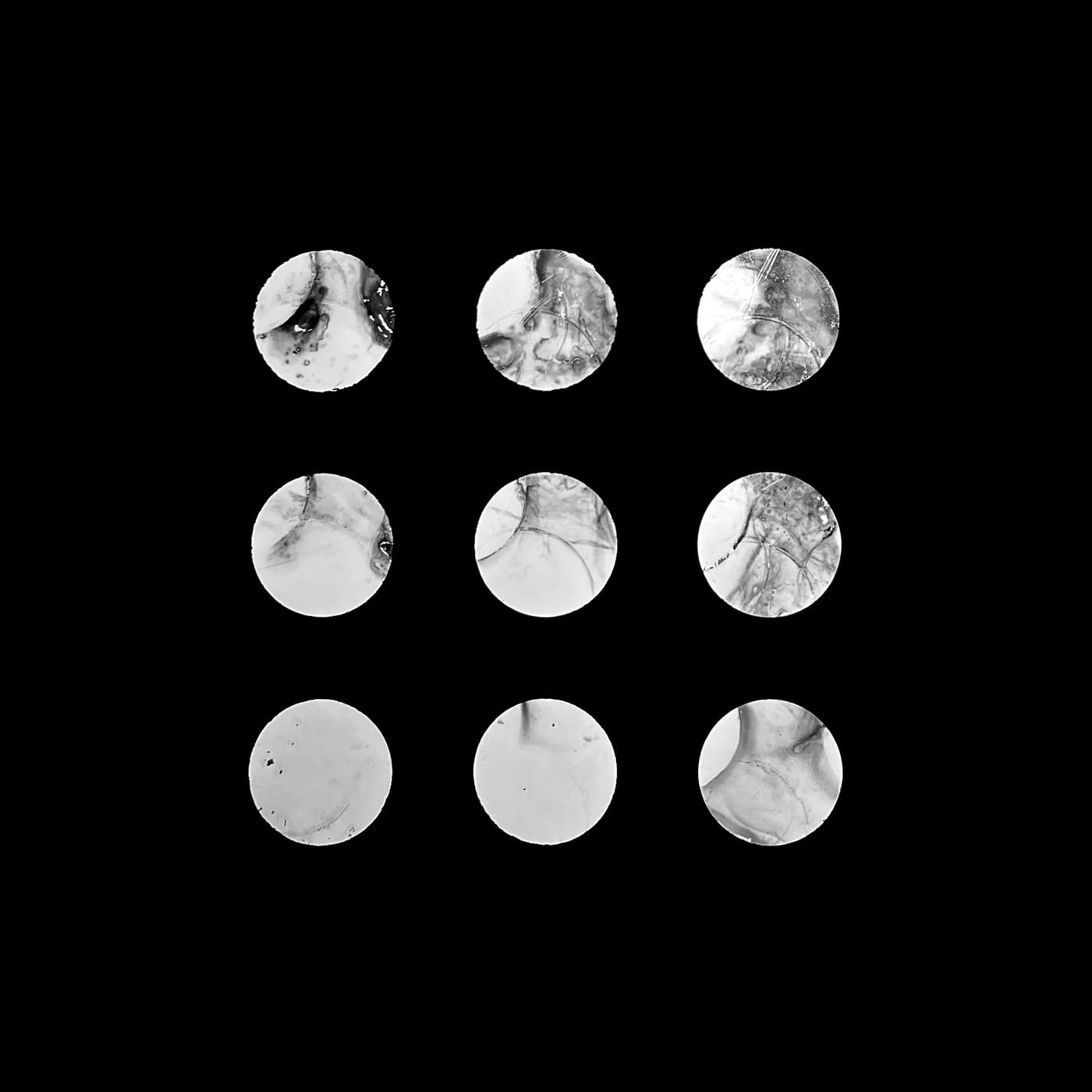 Nine pale discs arranged in a grid on black.