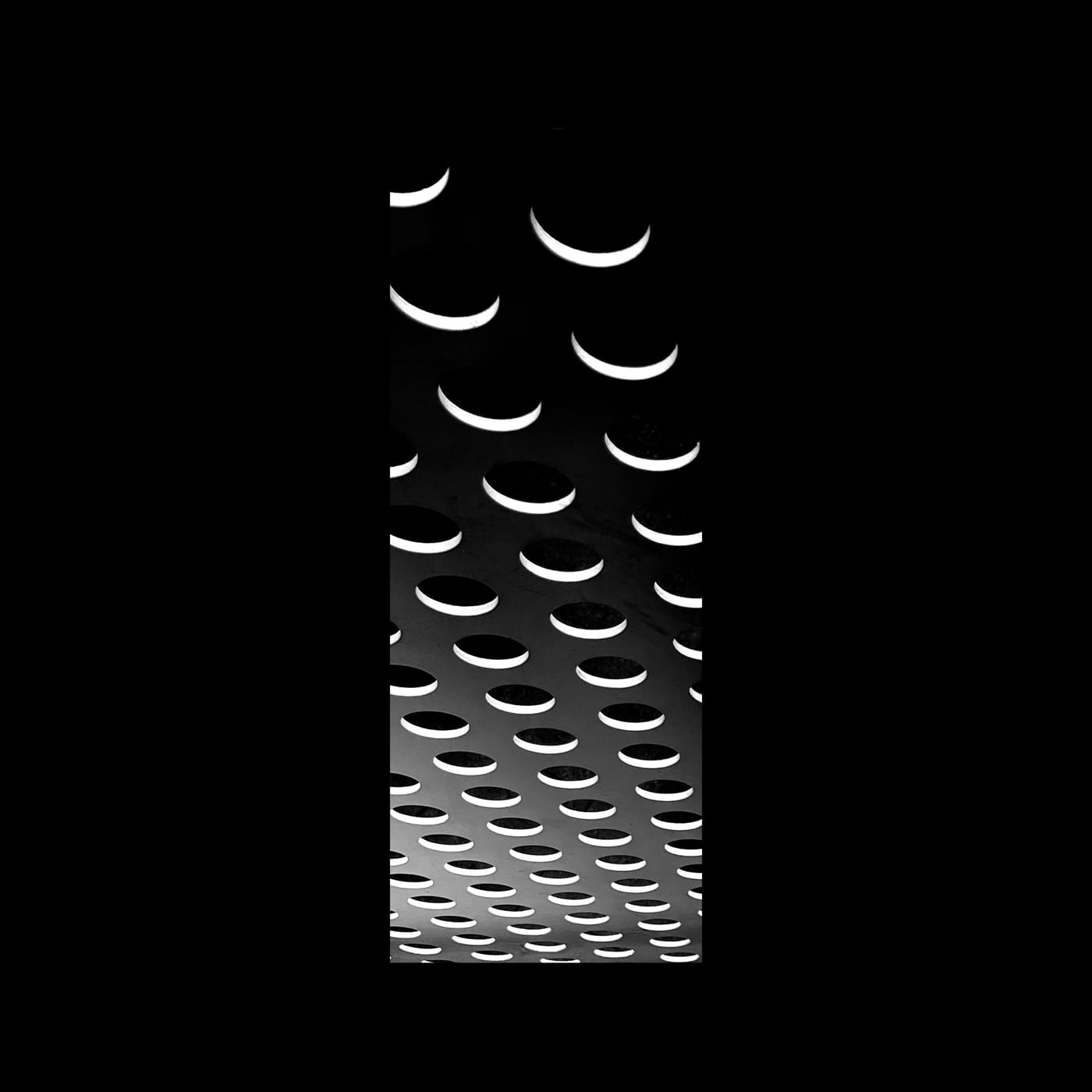 A field of small crescents fading from bright to black.